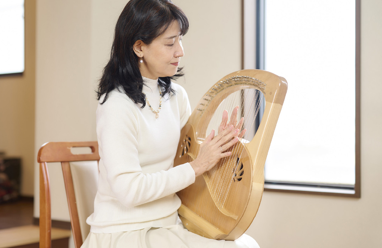ライアーを演奏している女性の写真